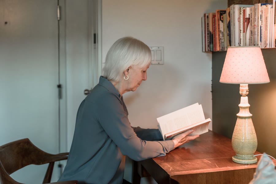 Persona leyendo junto a una lámpara al final del día